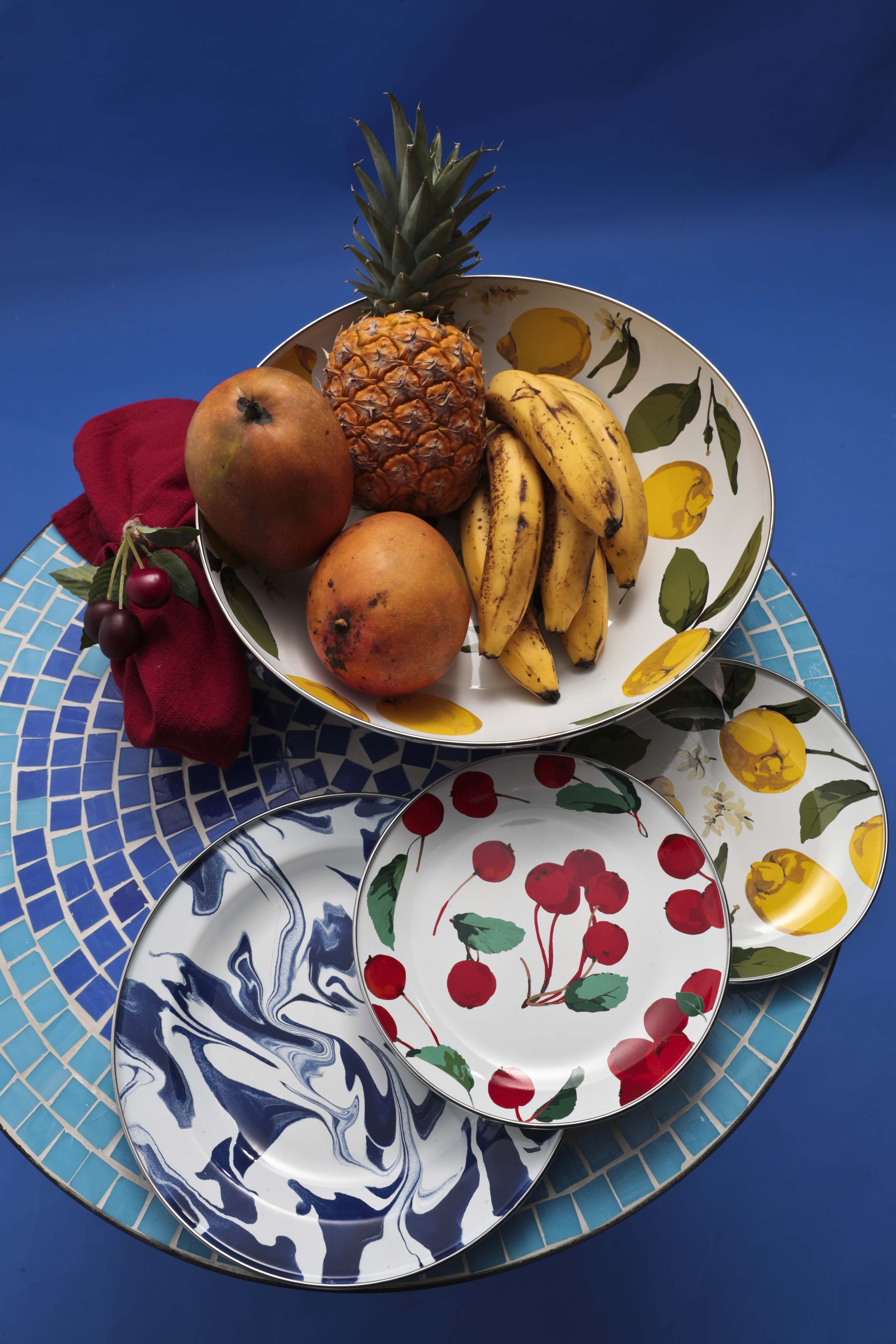 Mesa con tope de mosaico, de Bed, Bath and Beyond; platos de acero inoxidable con diseños esmaltados de frutas e imitando mármol, servilleta de hilo y anillo para servilleta con acento de cereza, de Pottery Barn. (Foto Wanda Liz Vega)
