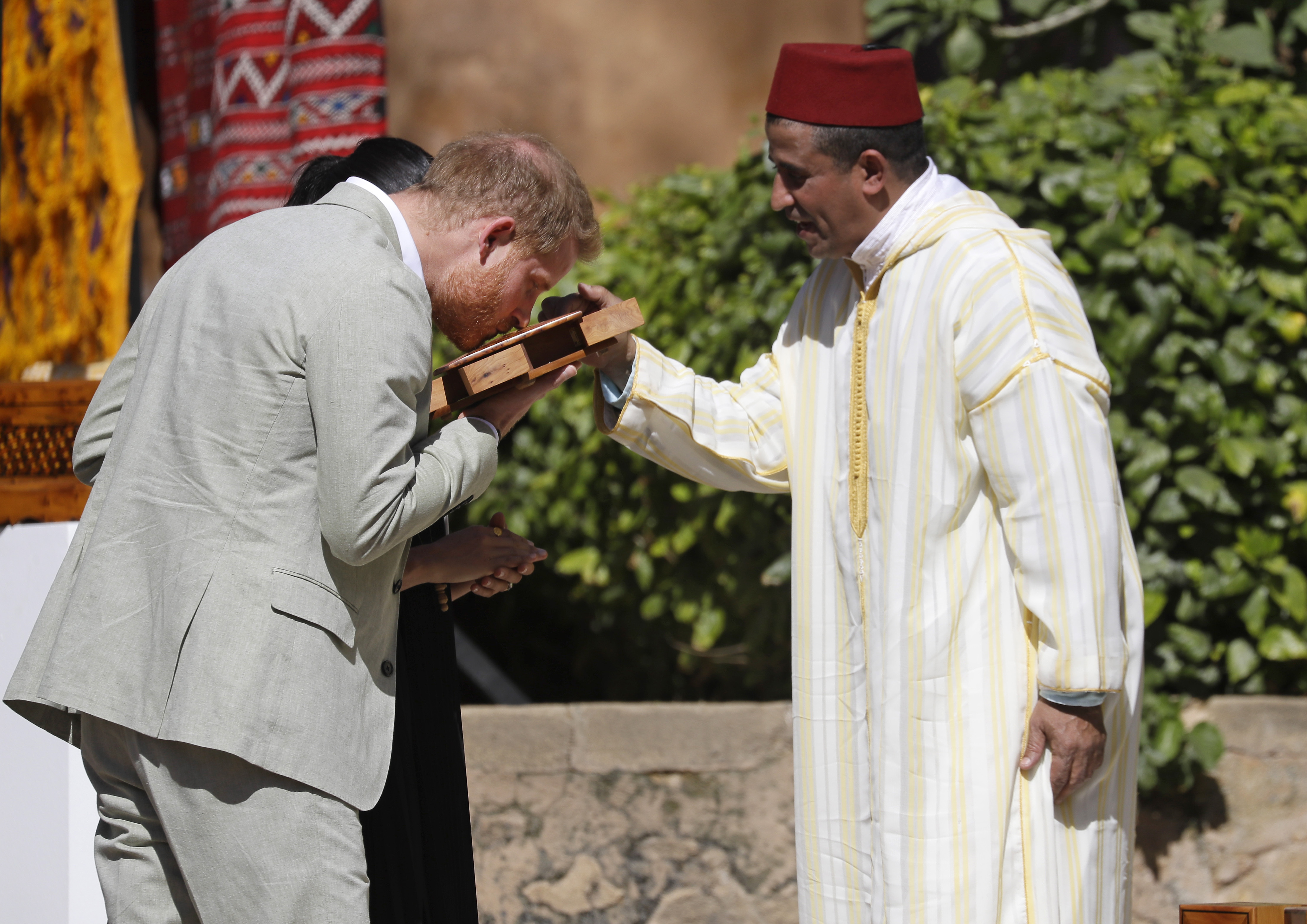 El príncipe Harry huele una caja de madera de cedro como parte de su visita a Rabat. (AP)