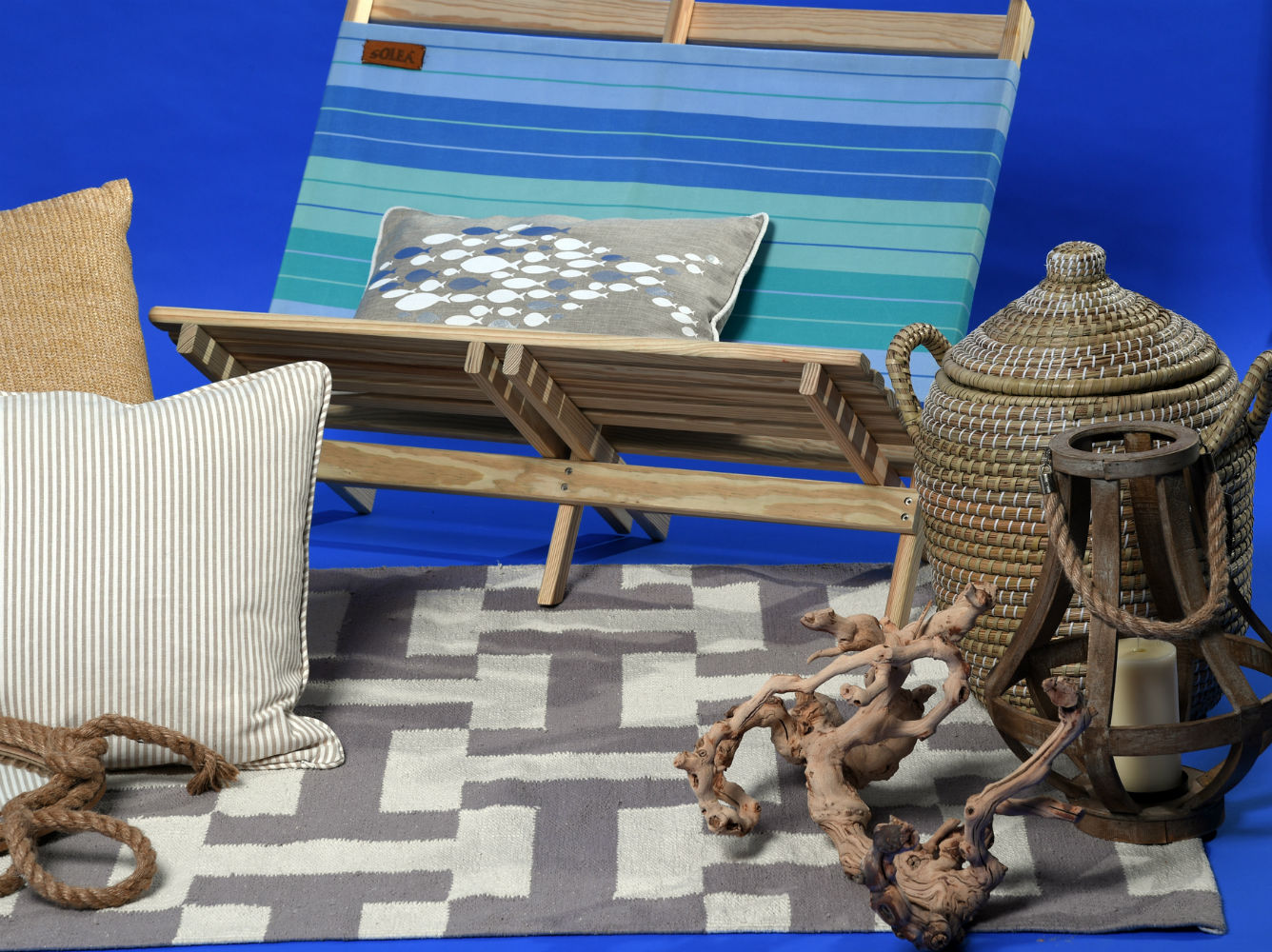 Cesto en paja, tronco y alfombra beige y blanca, de Cantópa; silla playera de lona para dos diseño de Solea, de Aaron Stewart Home. (André Kang)