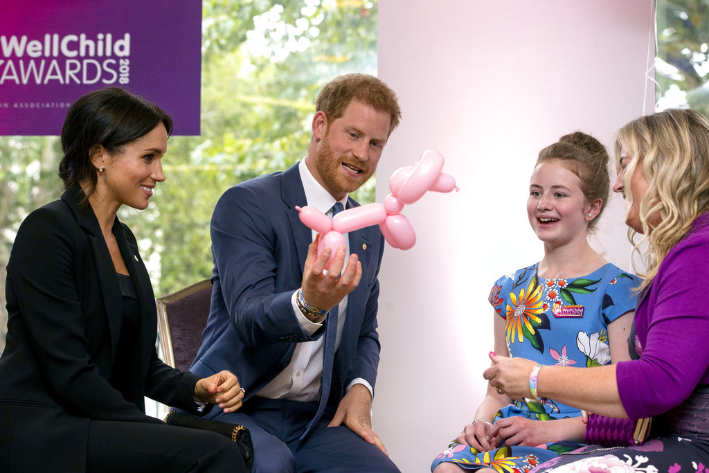 El príncipe Harry y Meghan Markle conversan y juegan con un perrito de bomba junto a Poppy y su madre Jayne en la gala anual de WellChild. (Foto: AP)