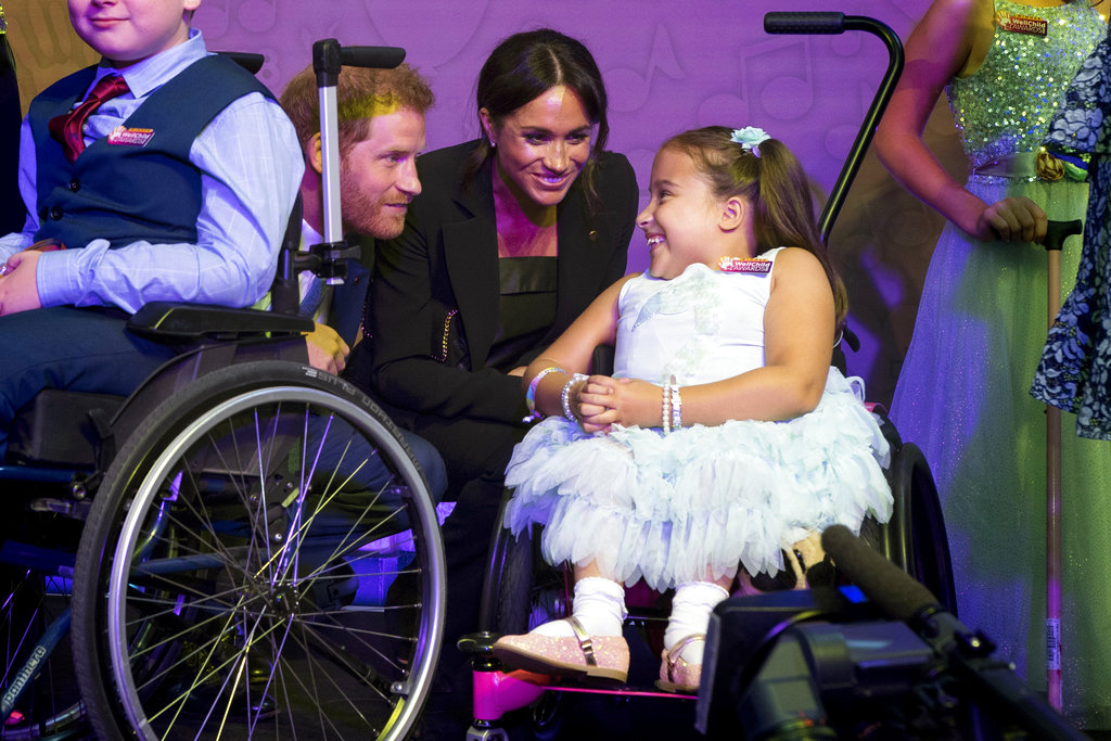Meghan Markle y el príncipe Harry saludan a Matilda Booth, de 7 años, durante la gala de WellChild. (Foto: AP)