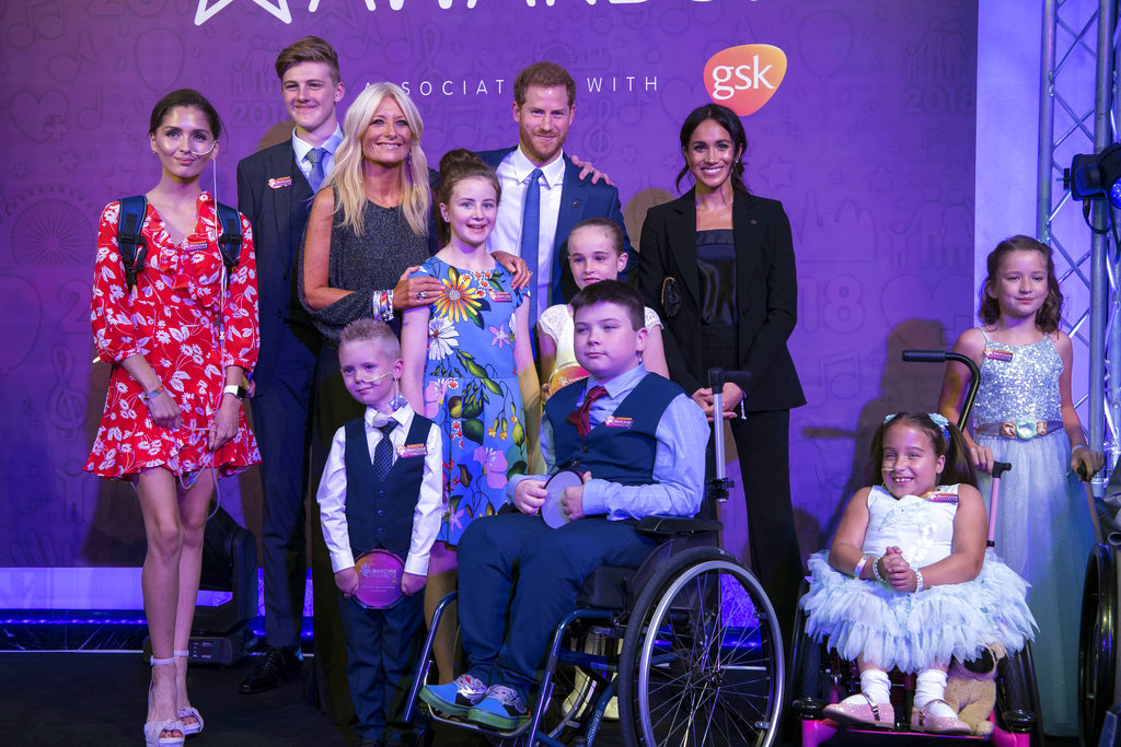 El príncipe Harry, padrino de la ong WellChild, y su esposa Meghan, junto a un grupo de niños en la gala anual de la entidad. (Foto: AP)