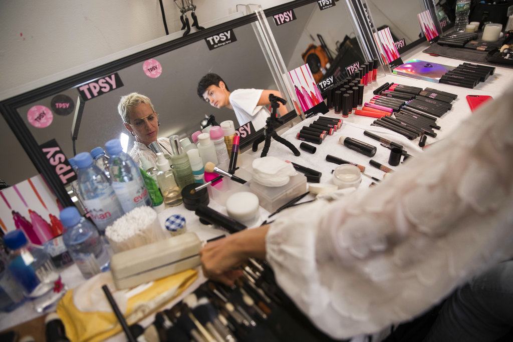 Una modelo elige pinceles mientras la maquillan y antes de presentar la colección primavera/verano 2019 de Milly. (Foto: AP)