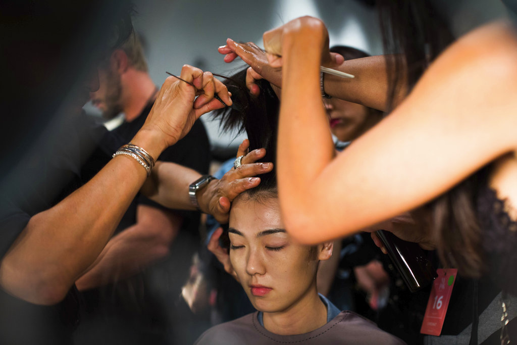 Dos estilistas trabajan en una de las modelos del desfile de The Blonds que lleva como tema a las villanas de Disney en el NY Fashion Week. (Foto: AP)