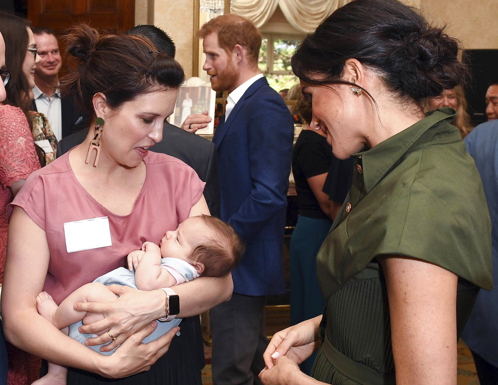 Meghan observa con ternura a Lunar, el bebé de 9 meses de la cantante australiana Missy Higgins durante una recepción ofrecida por el gobernador general de Australia. (Foto:AP)