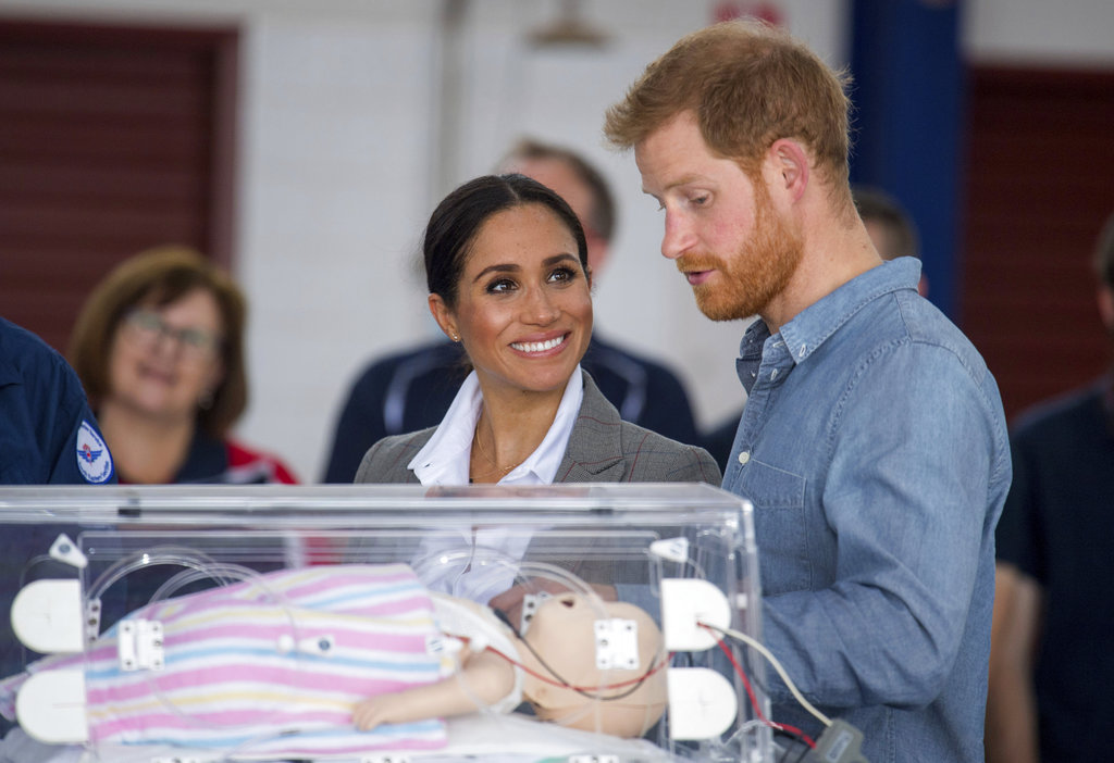 Meghan observa con una gran sonrisa a su esposo mientras les enseñan un equipo de entrenamiento que simula a un bebé en una incubadora mientras asisten a la presentación de un nuevo avión sanitario en el Aeropuerto Regional de Dubbo. (Foto: Ap)