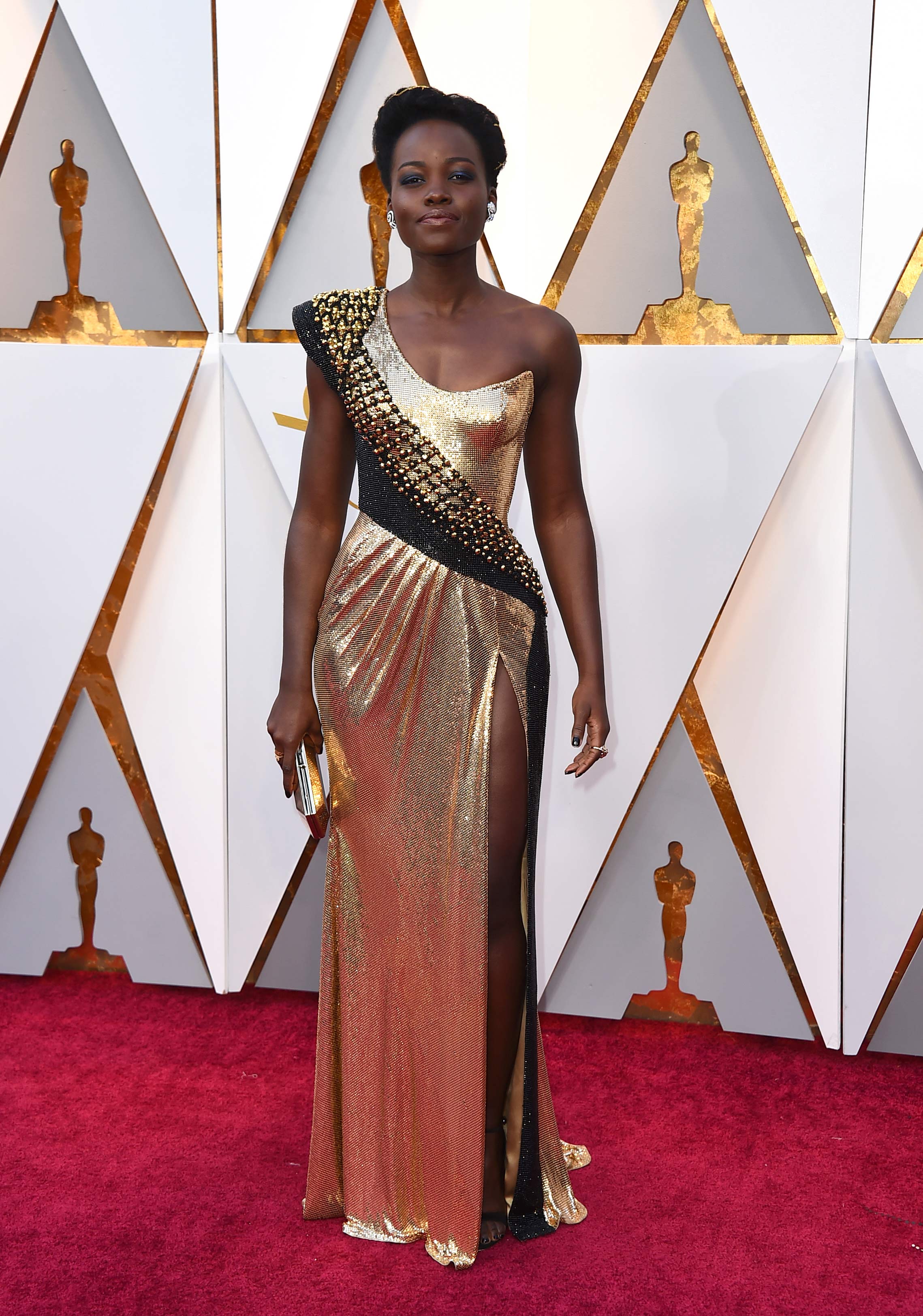 Lupita Nyong´o fue otra de las actrices que eligió un vestido en tonos metalizados, de la firma Versace, para la ceremonia de los Oscar. (The Associated Press)