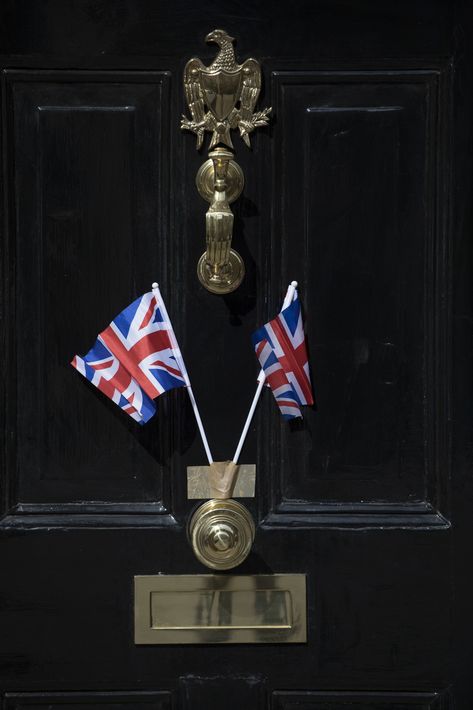 Dos mini banderines del "Union Jack" adornan la puerta de una casa en el pueblo de Windsor, donde tendrá lugar la boda real mañana sábado al mediodía.(AP Photo/Peter Dejong)