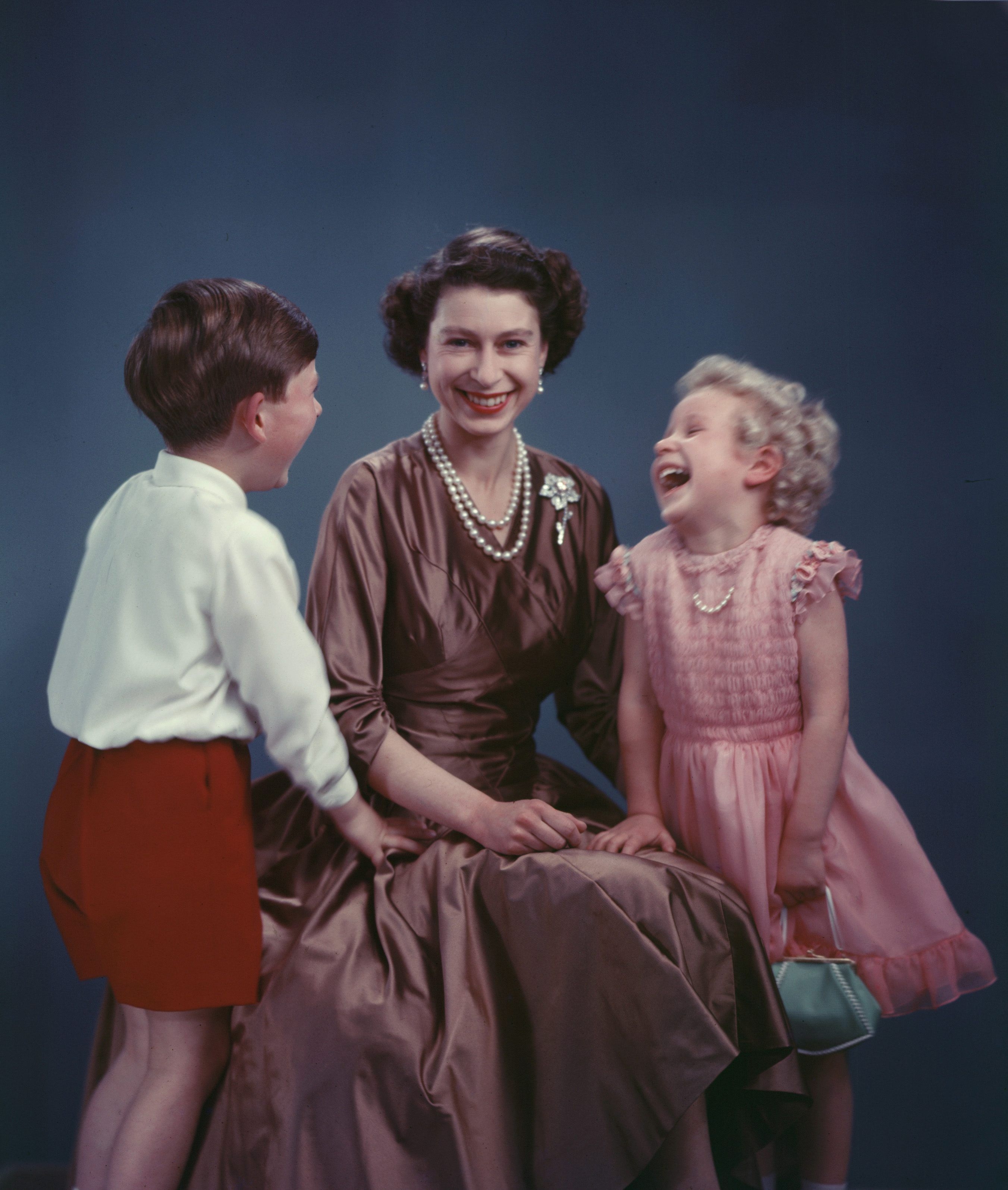 Retrato de la reina Elizabeth II junto a sus hijos los príncipes Charles y Anne tomado en noviembre de 1954 Esta imagen formó parte de un libro y una exposición titulada “Marcus Adams: Fotógrafo real” que se mostró en The Queen's Gallery de Edimburgo entre febrero y junio de 2011. (Archivo)