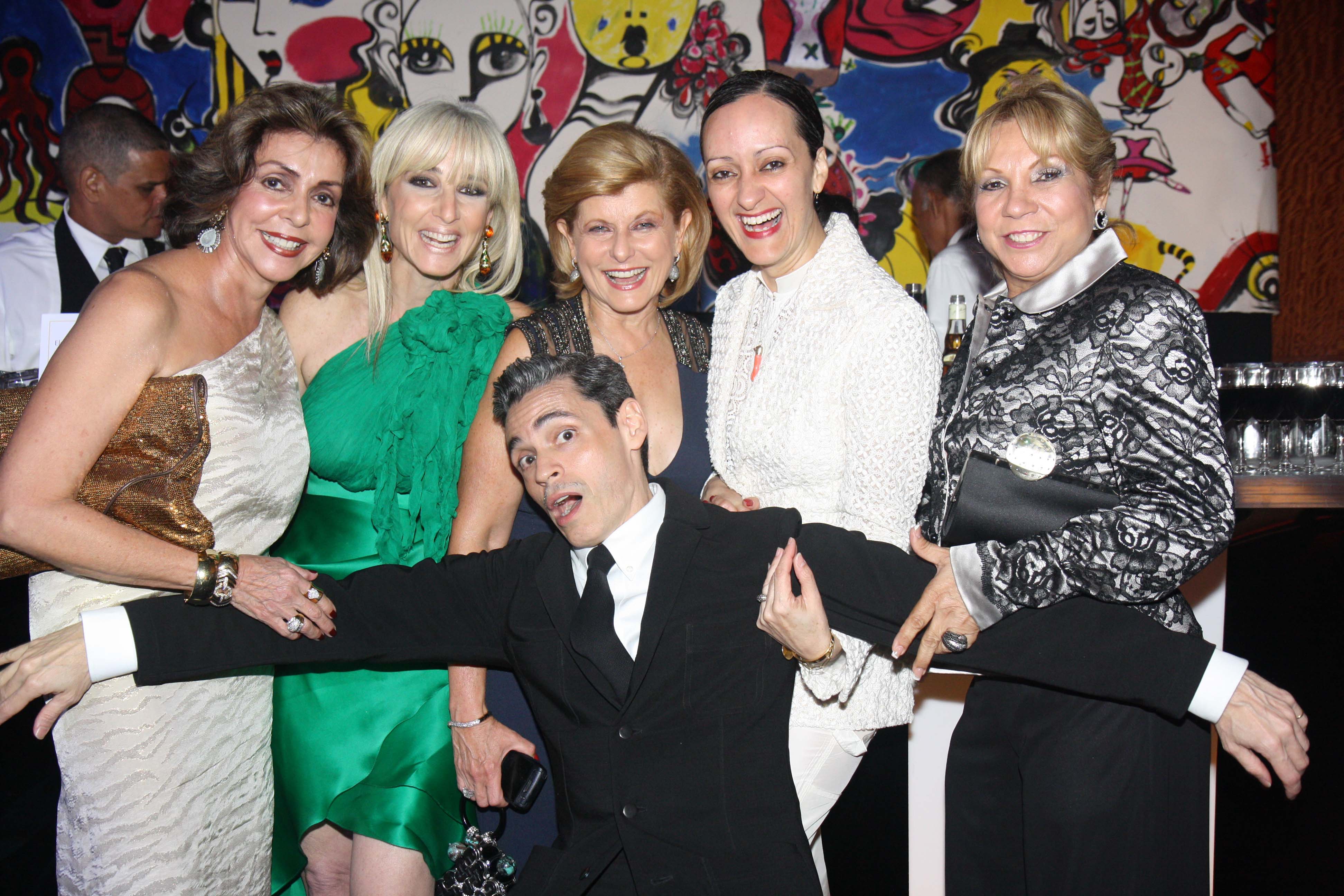 Haciendo gala de su sentido del humor, Ruben Toledo se lanza -ante el lente de Magacín- sobre Marisita Cortés, Mercy Short, Zoila Levis, Isabel Toledo y Aidita Gnocchi, en la inauguración de la exhibición de su esposa. (Foto Archivo GFR Media)