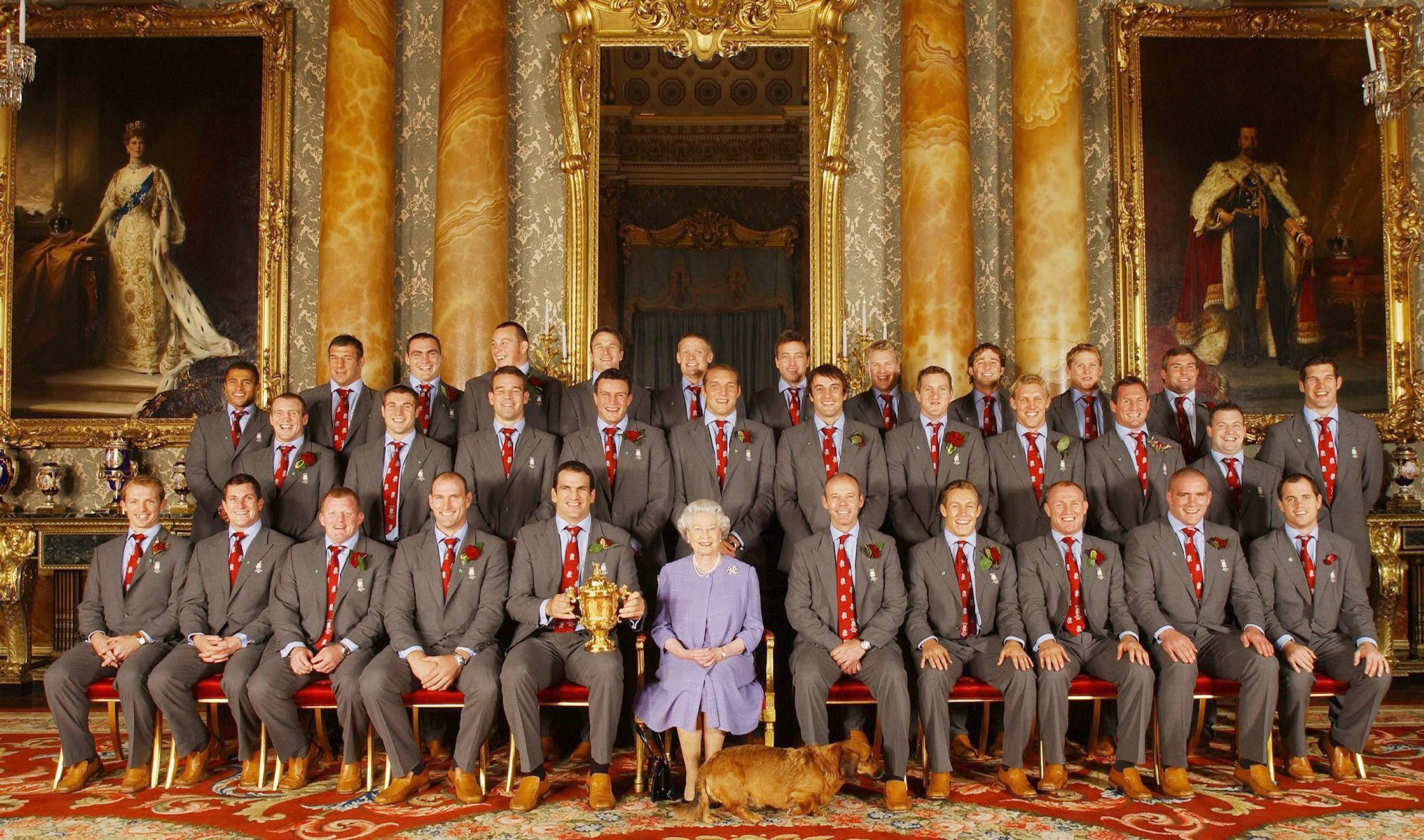La reina de Inglaterra posa con los jugadores del equipo nacional de rugby, durante una recepción oficial en el Palacio de Buckingham para celebrar la consecución del Campeonato del Mundo de Rugby en agosto de 2003. (Archivo)