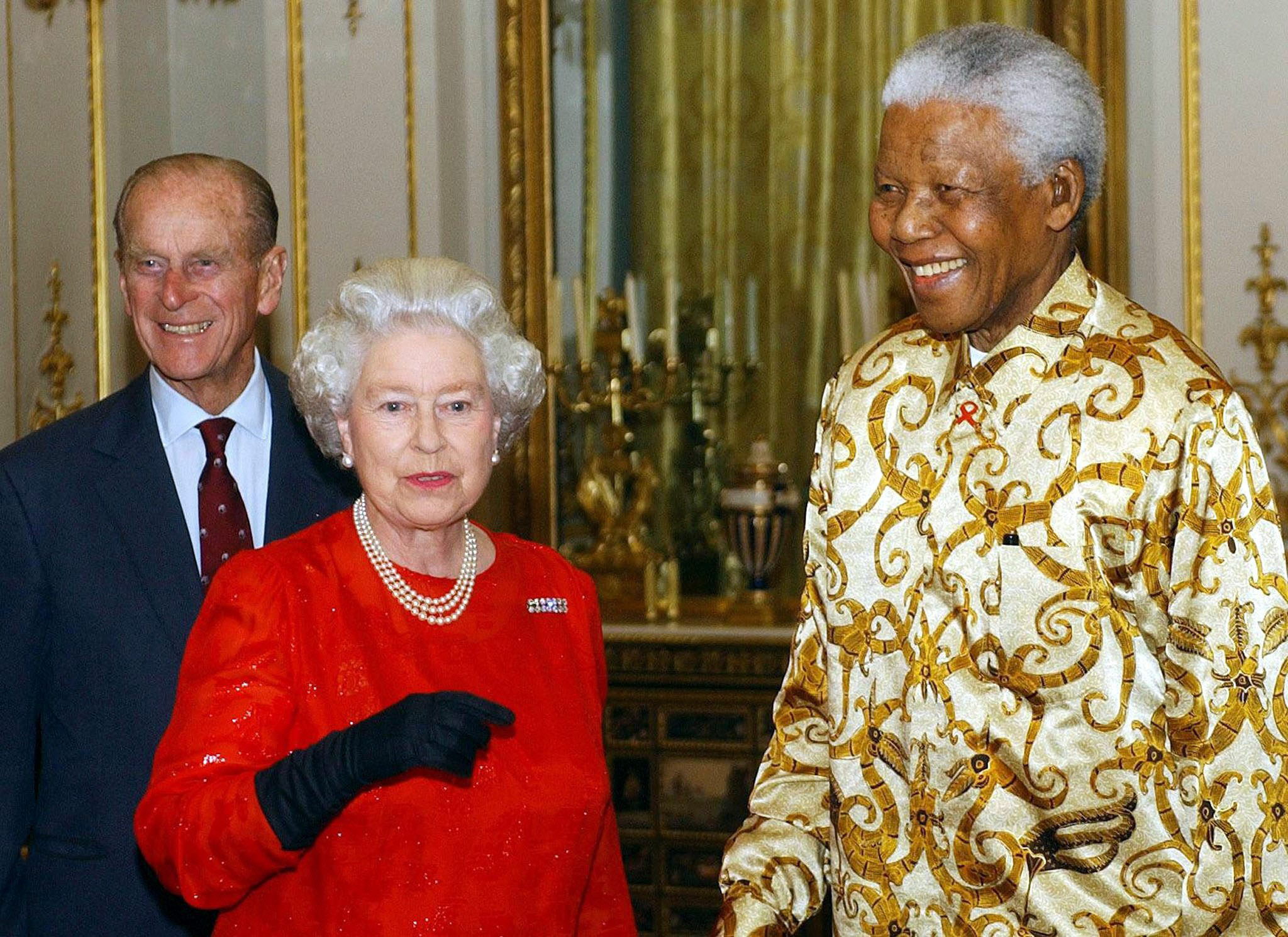 La reina y el duque de Edimburgo saludan al expresidente de África del Sur, Nelson Mandela durante una recepción en el Palacio de Buckingham en octubre de 2003. En esa ocasión se celebró el centenario de la fundación Rhodes Trust, iniciada por el empresario Cecil John Rhodes en el siglo 19, para proveer becas a estudiantes del mundo para estudiar en la Universidad de Oxford. (Archivo)