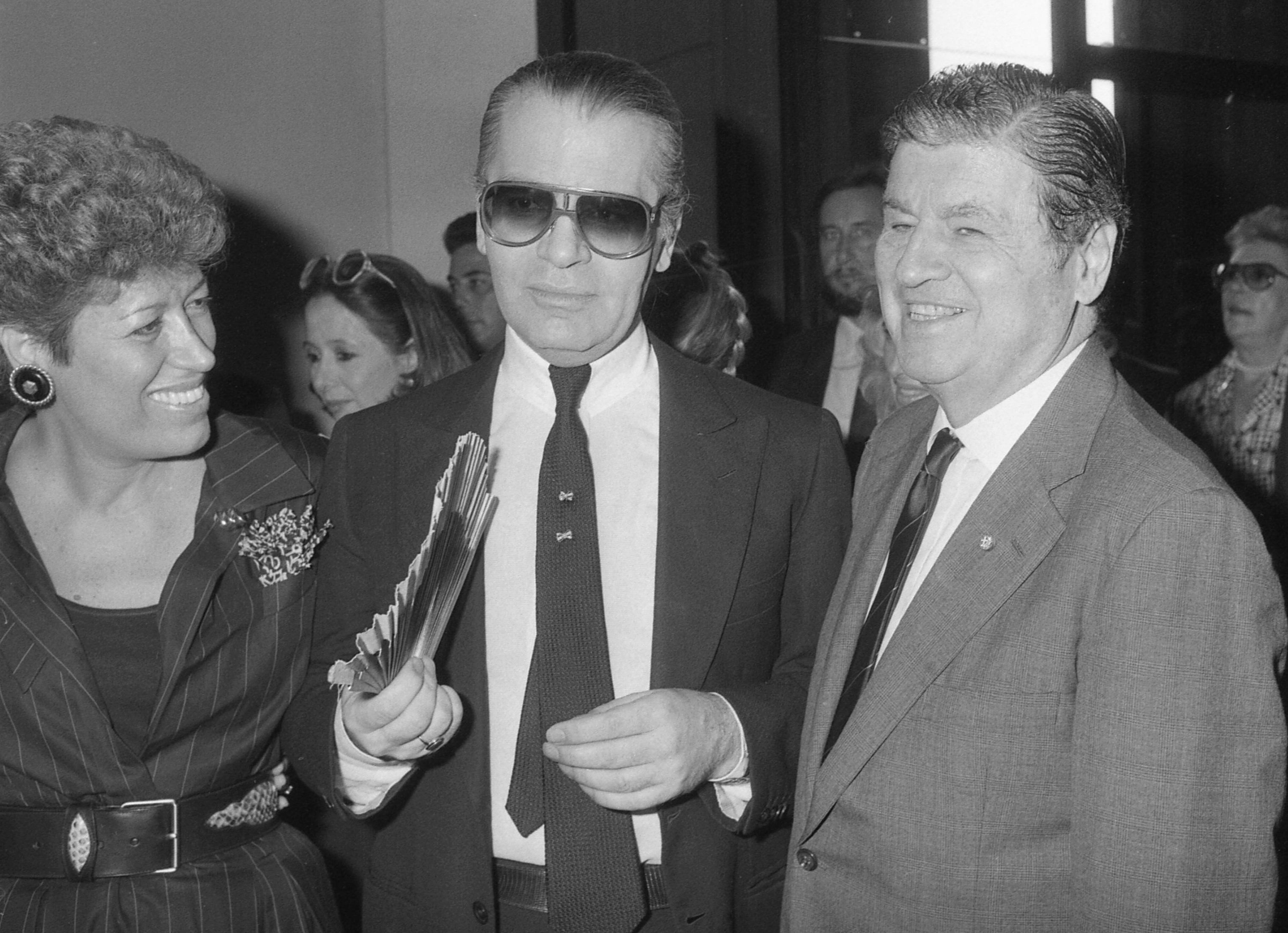 Carla Fendi, portavoz de la familia Fendi, Karl Lagerfeld y el embajador estadounidense, Maxwell Rabb, durante la apertura de una exhibición en la Galería Nacional de Arte Moderno en Roma en octubre de 1985. (AP)