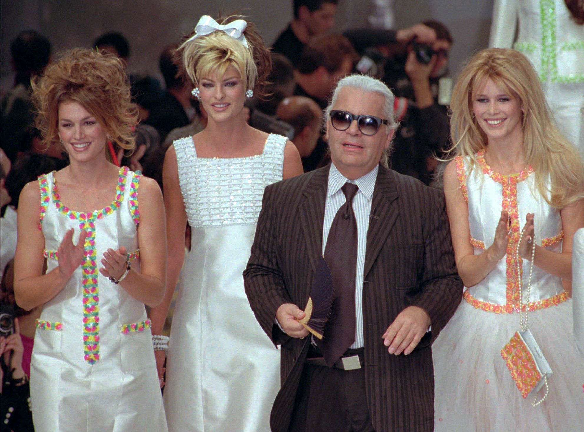 Lagerfeld siempre estuvo rodeado de las modelos más famosas. En este desfile celebrado en París en octubre de 1995 sale a saludar al público acompañado de las “super models” Cindy Crawford, Linda Evangelista y Claudia Schiffer. (AP)