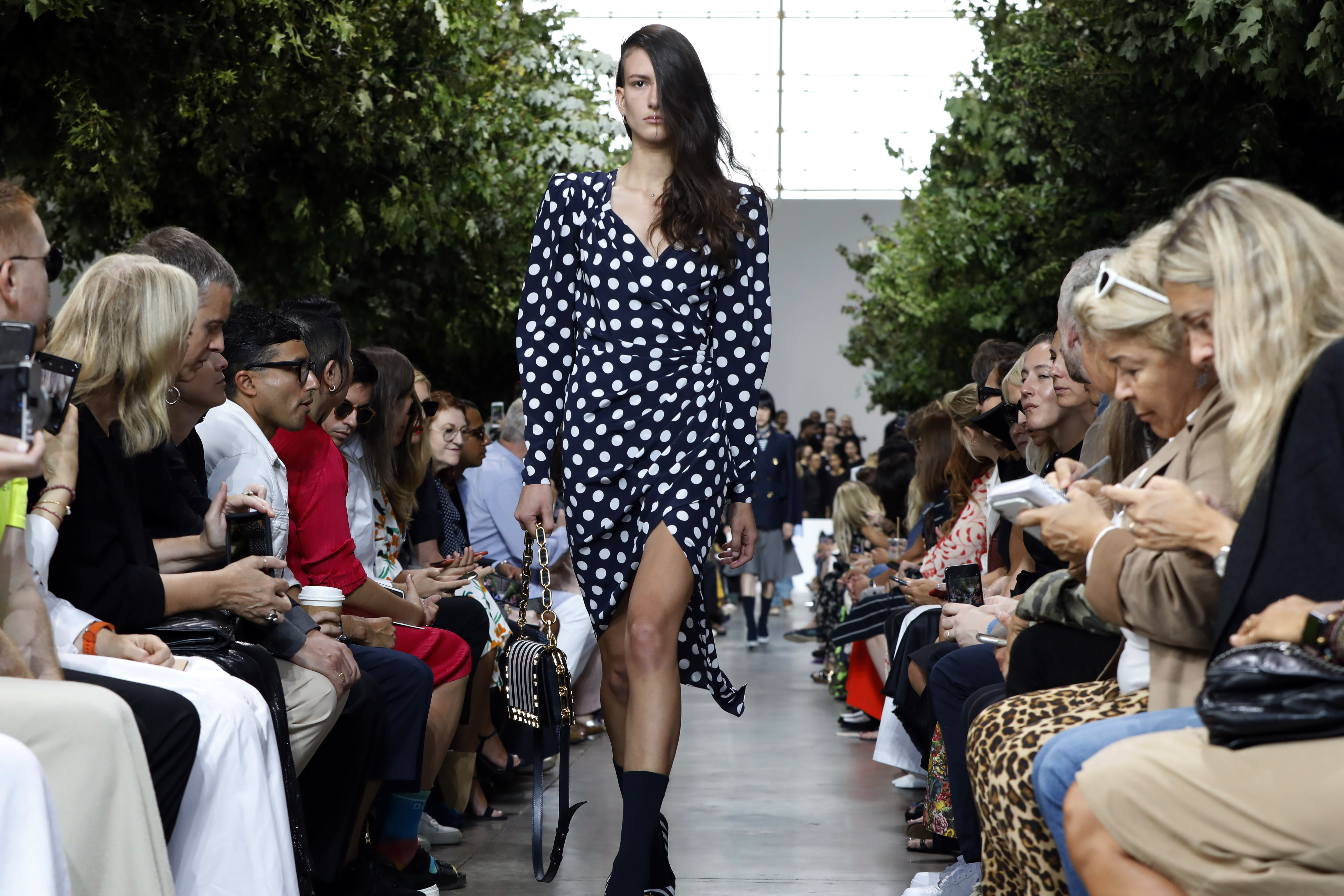 Kors recreó un parque con árboles dentro de una nave industrial de Brooklyn. (AP)