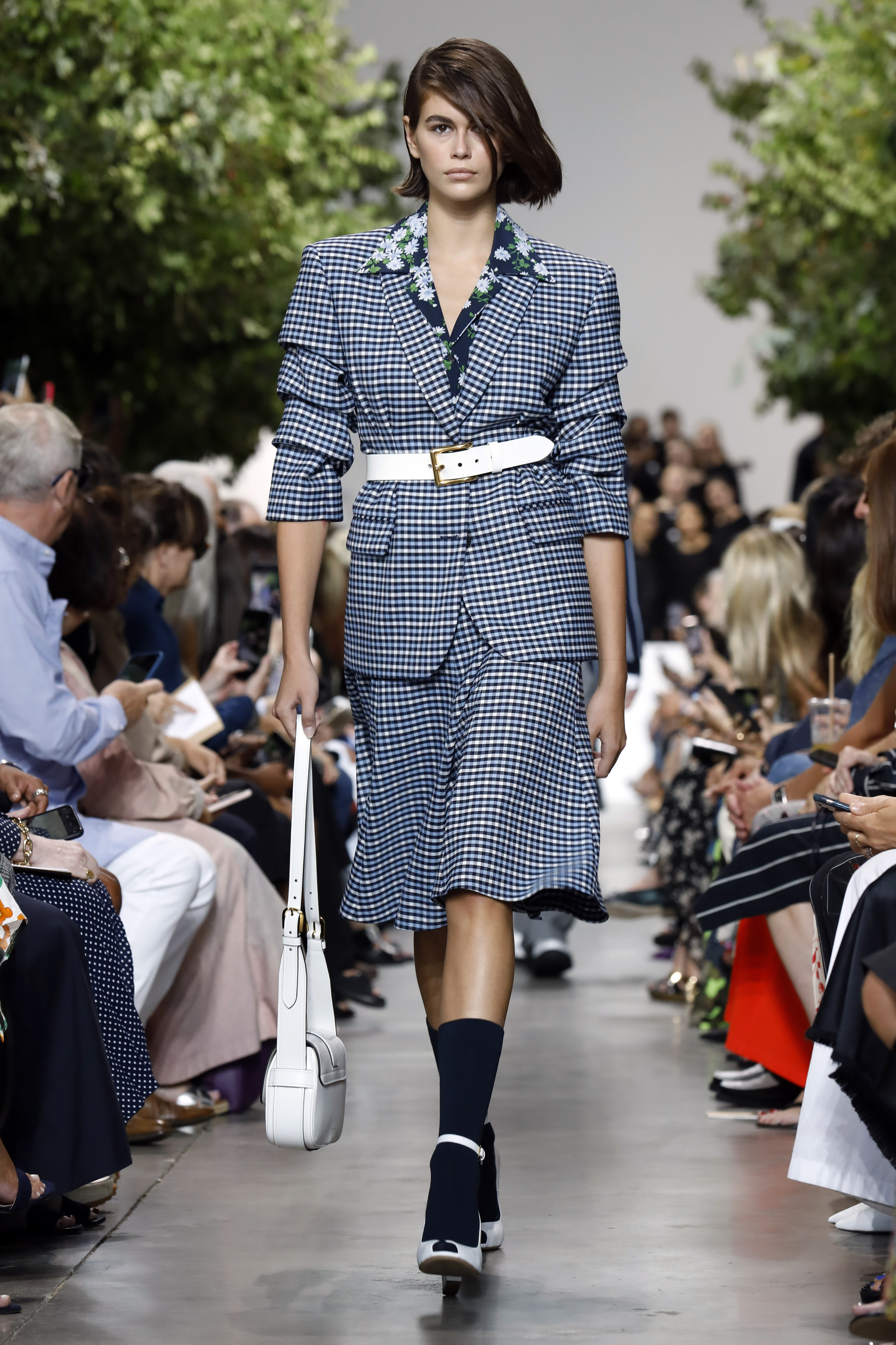 Kaia Gerber lució traje de chaqueta y falda de cuadros sobre camisa de flores. (AP)