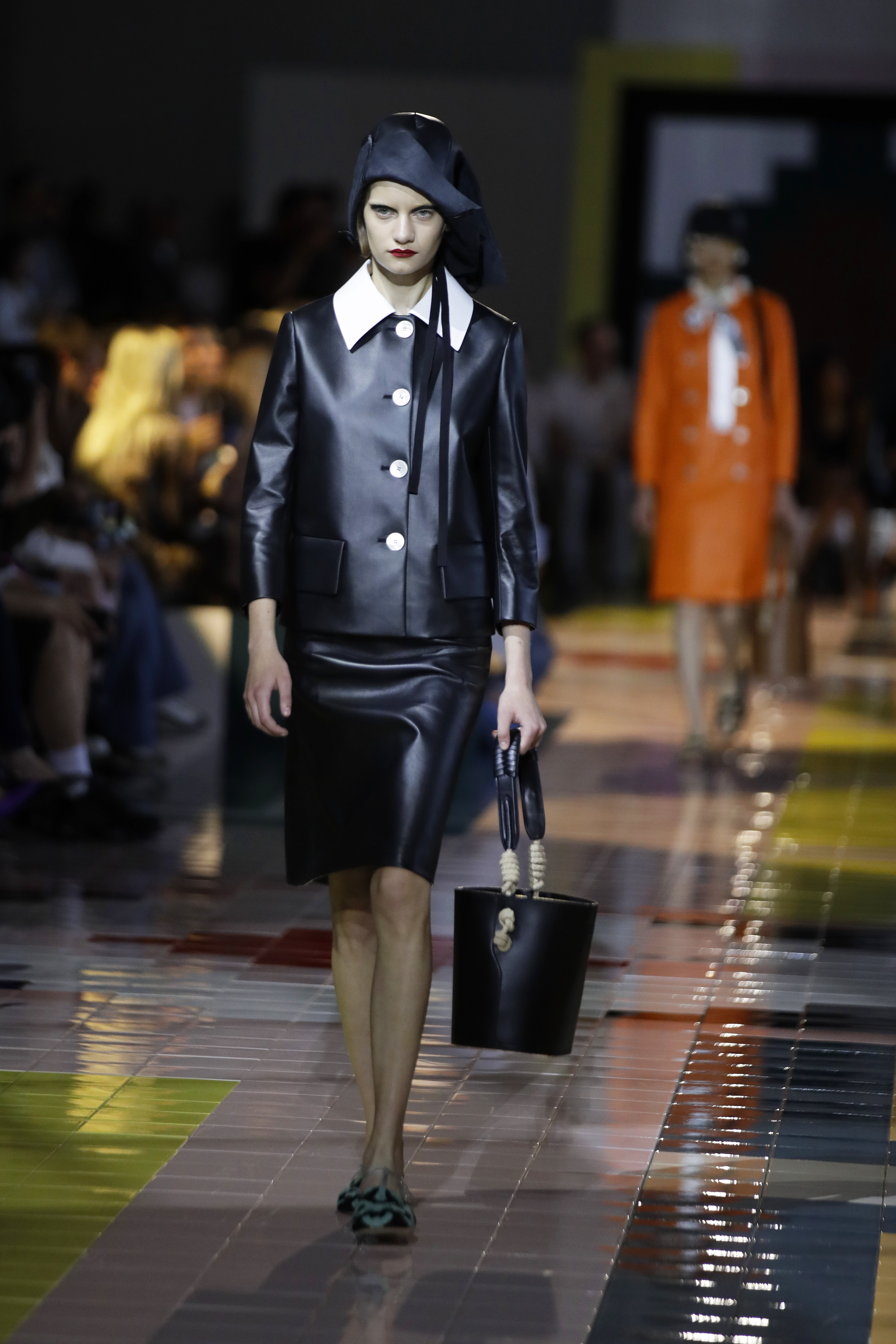 La chaqueta negra con cuatro botones verticales en blanco compone un “look” elegante con las solapas de una camisa blanca que se colocan por encima de la chaqueta y debajo una falda negra de silueta lápiz y botas altas. (AP)