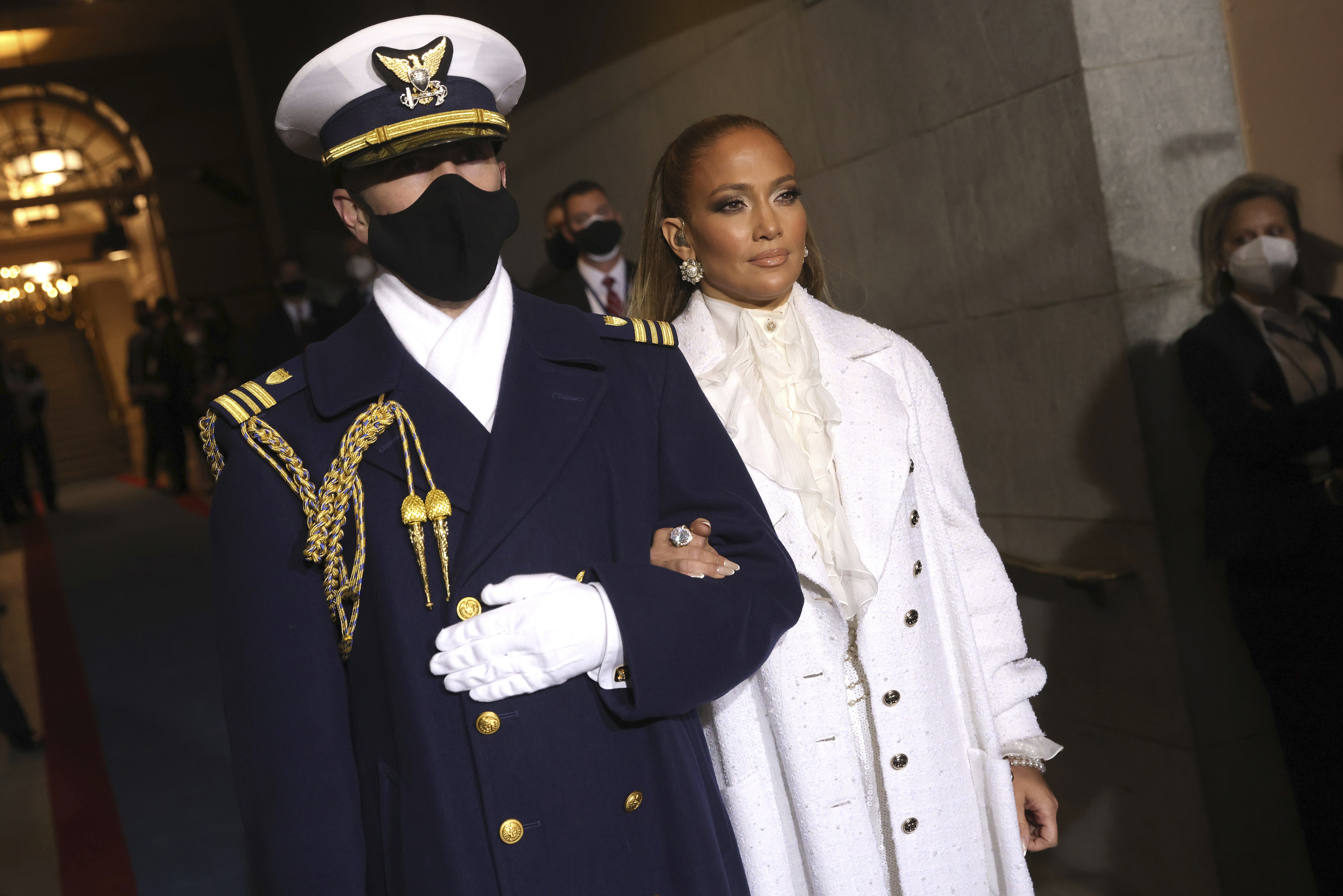 Jennifer López entonó los temas “America the Beautiful” y “Let's Get Loud” en la ceremonia. Para la ocasión optó por un glamouroso conjunto de pantalón, abrigo y blusa de cuello amarrado en color blanco de la casa de moda francesa Chanel. (AP)