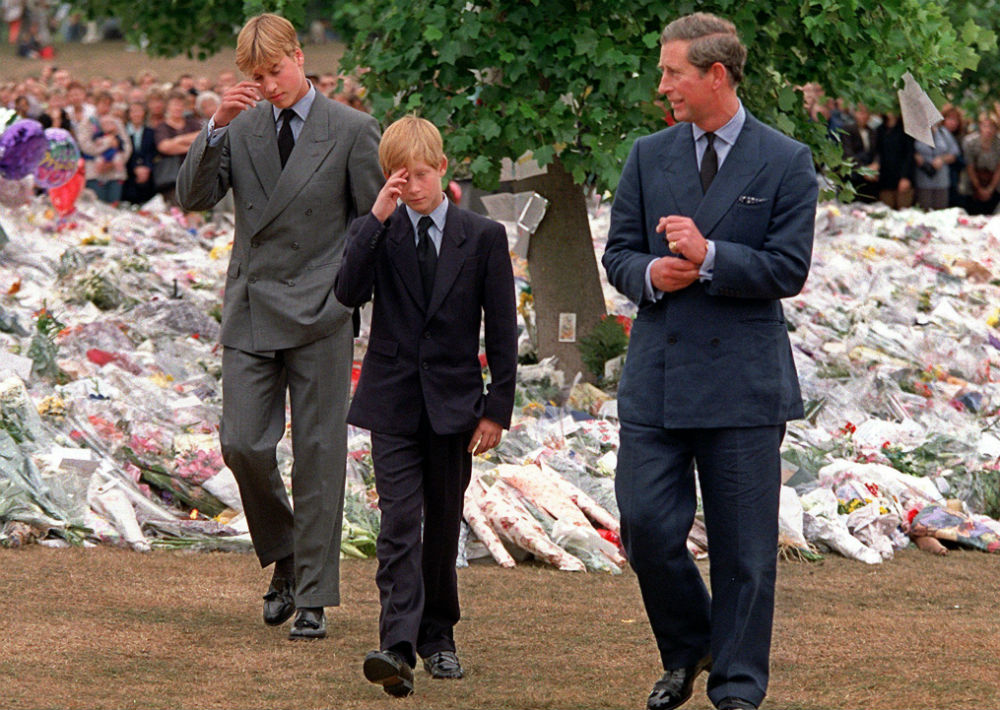 5 de septiembre de 1997. El príncipe de Gales acompaña a sus hijos, los príncipes William y Harry, mientras caminan el Kensington Palace y observan los tributos a la princesa Diana tras su trágica muerte. (AP)