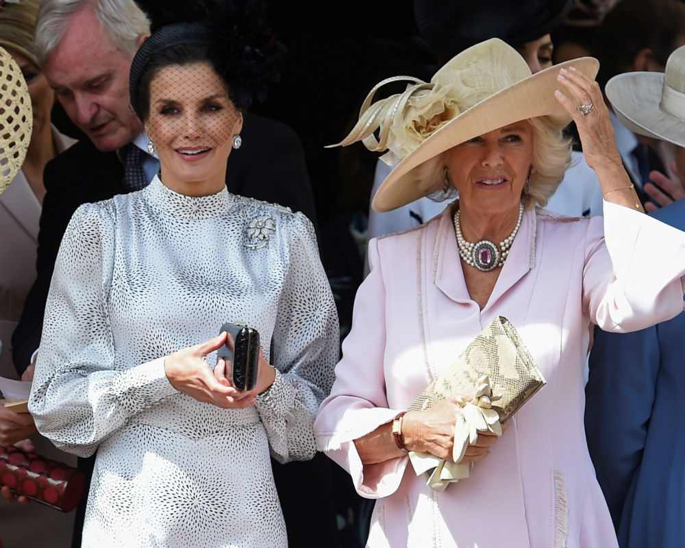 Para la ocasión, la reina Letizia optó por un vestido midi y un tocado negro con pequeñas plumas y pantallas de diamantes que forman parte de la colección de la Casa Real Española. (EFE)