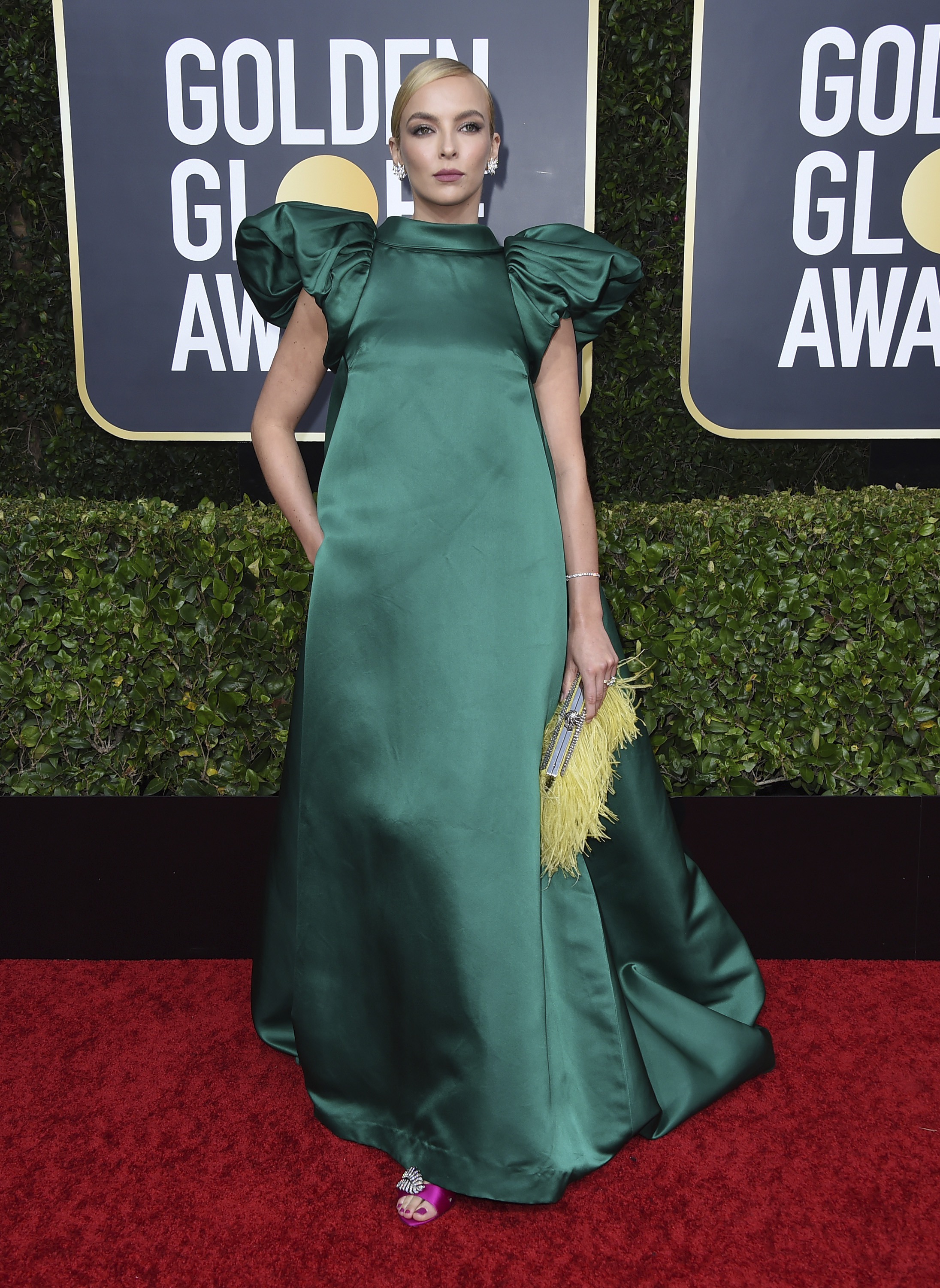 La estrella de "Killing Eve", Jodie Comer optó por un modelo esmeralda en seda de Mary Katrantzou con una cartera amarilla tipo "clutch" de Jimmy Choo y joyas Tiffany & Co..(AP)