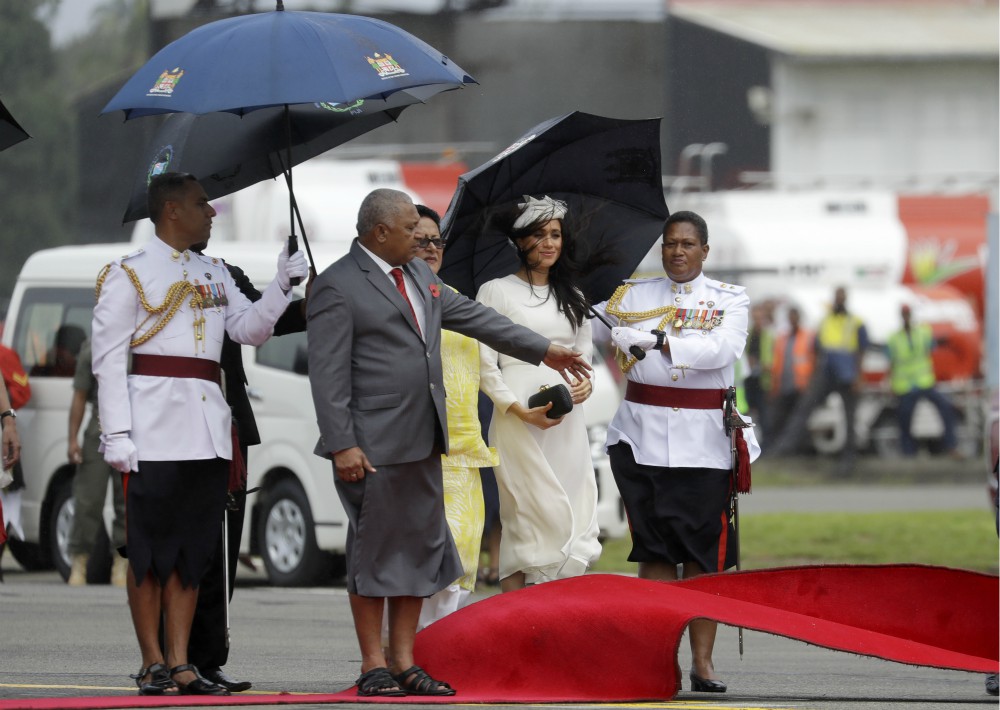 Lo complicó un poco la llegada fue el viento que sopló con fuerza hasta levantar la alfombra roja y -en ocasiones- amenazó con llevarse volando el tocado de Stephen Jones que lucía Meghan. (Foto: AP)