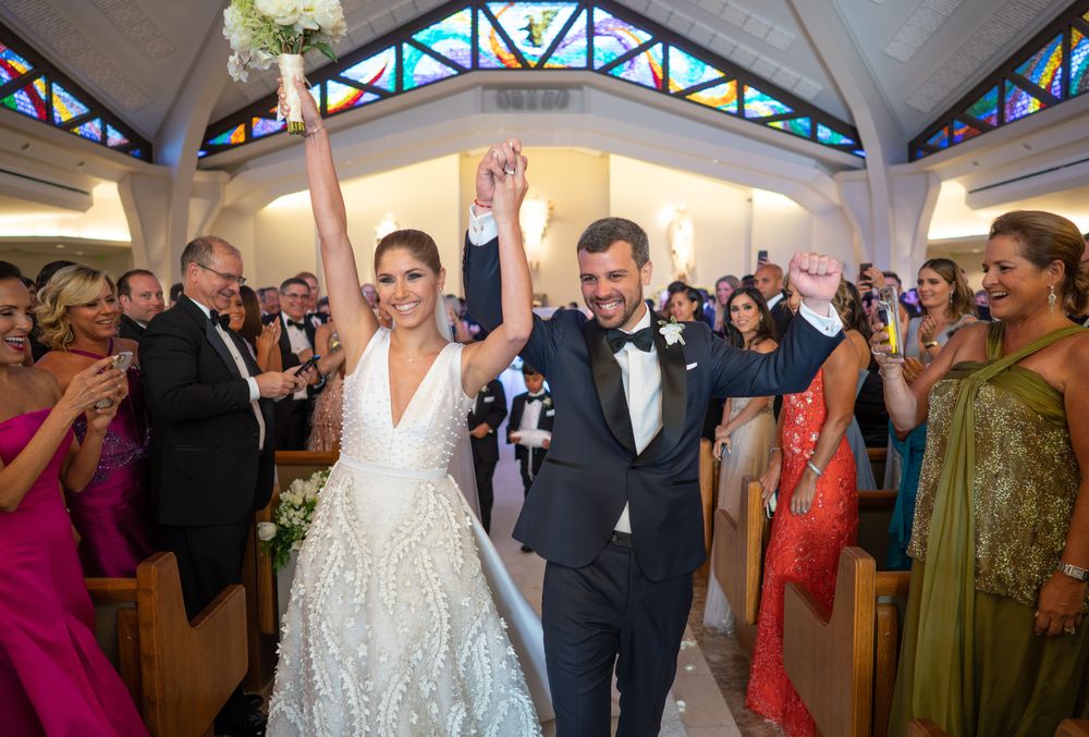Los novios, jubilosos, en el recesional. José Emilio vistió una creación a la medida del diseñador Ian Ríos. Fotografía Wilo Rosado