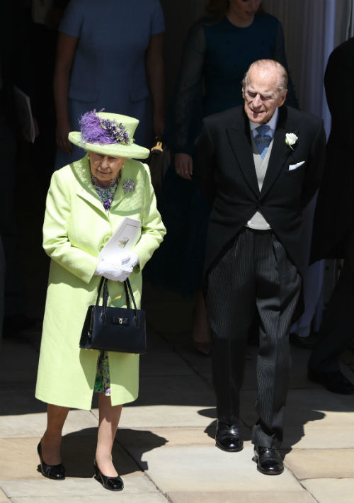 La reina Elizabeth II vistió un conjunto en tonos claros de verde con acentos púrpura. (AP)