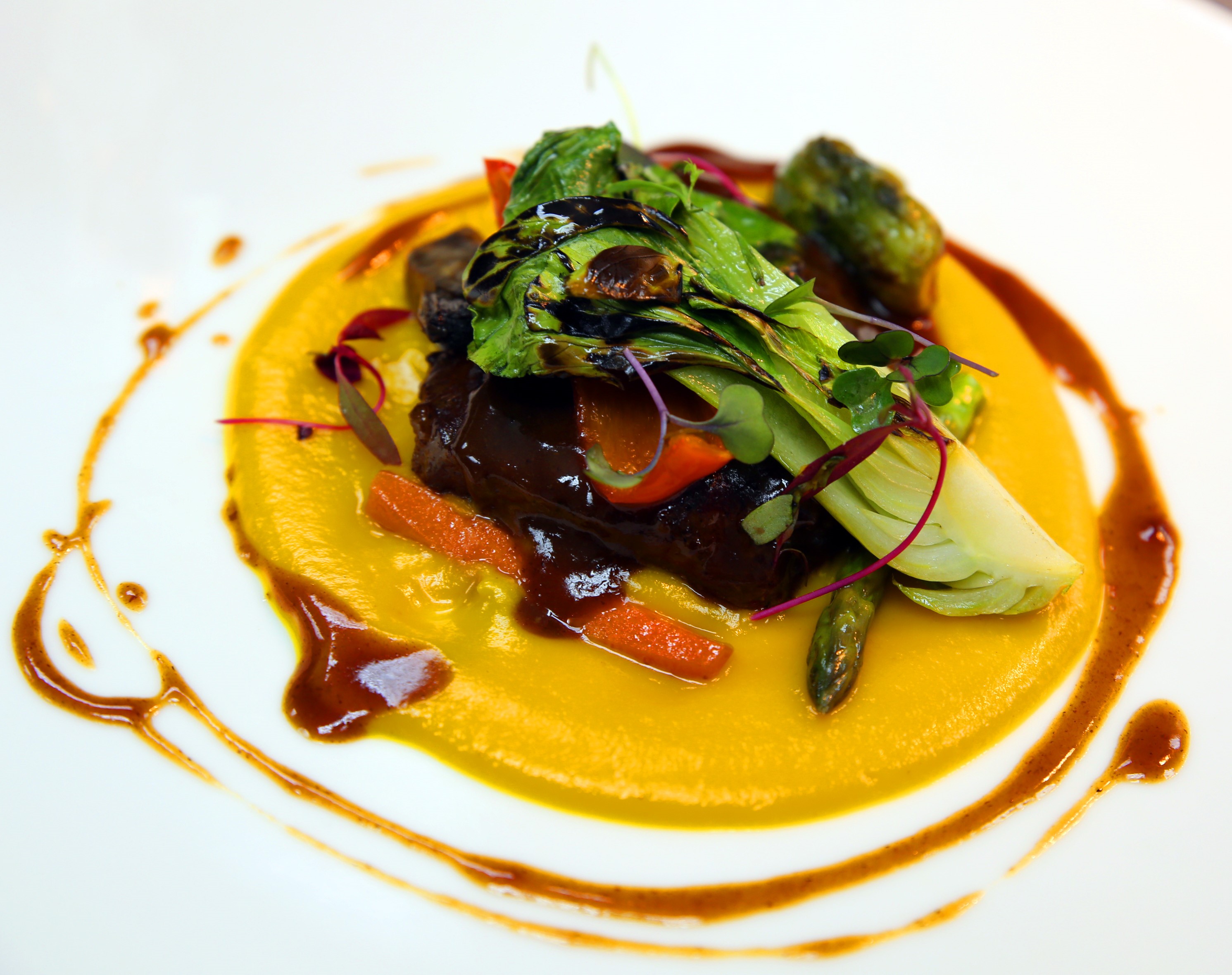 Cachete de Cerdo estofado sobre puré de calabaza y coco, vegetales asados y jugo de cocción. Foto suministrada.
