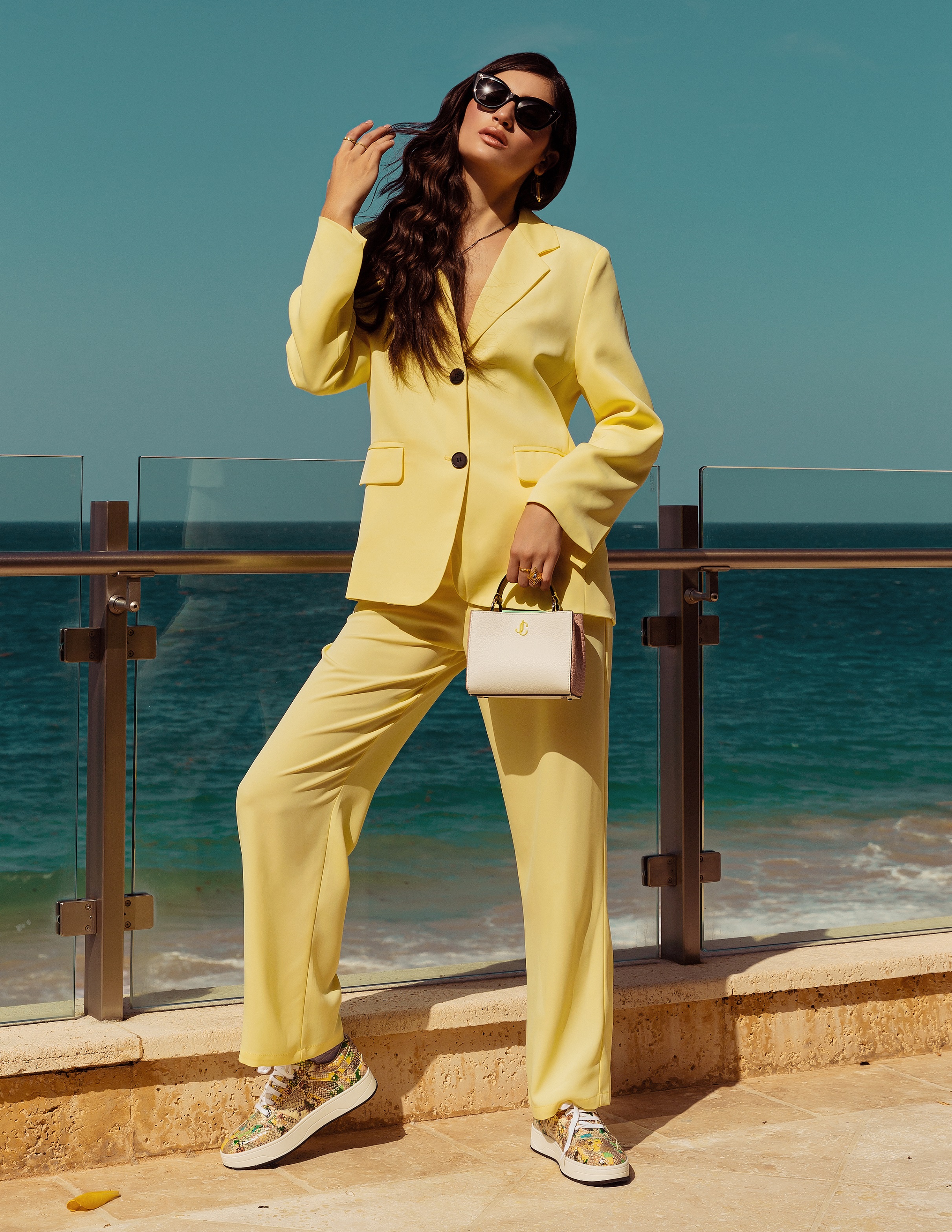 Suit amarillo, de Never Overdressed; calzado y bolso, de Jimmy Choo; joyería, de Reinhold Jewelers; y gafas Oliver’s People, de Olivia’s Boutique. (Foto: Nolan Rivera/ Especial para Magacín)