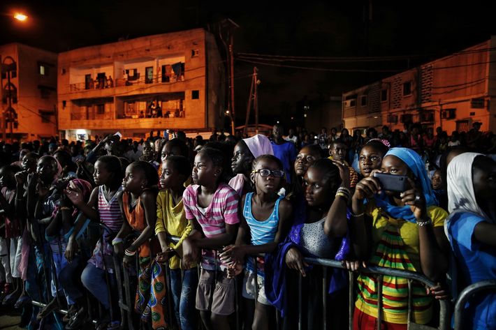Jóvenes senegaleses ven un desfile al aire libre durante la Semana de la Moda de Dakar. (Prensa Asociada)