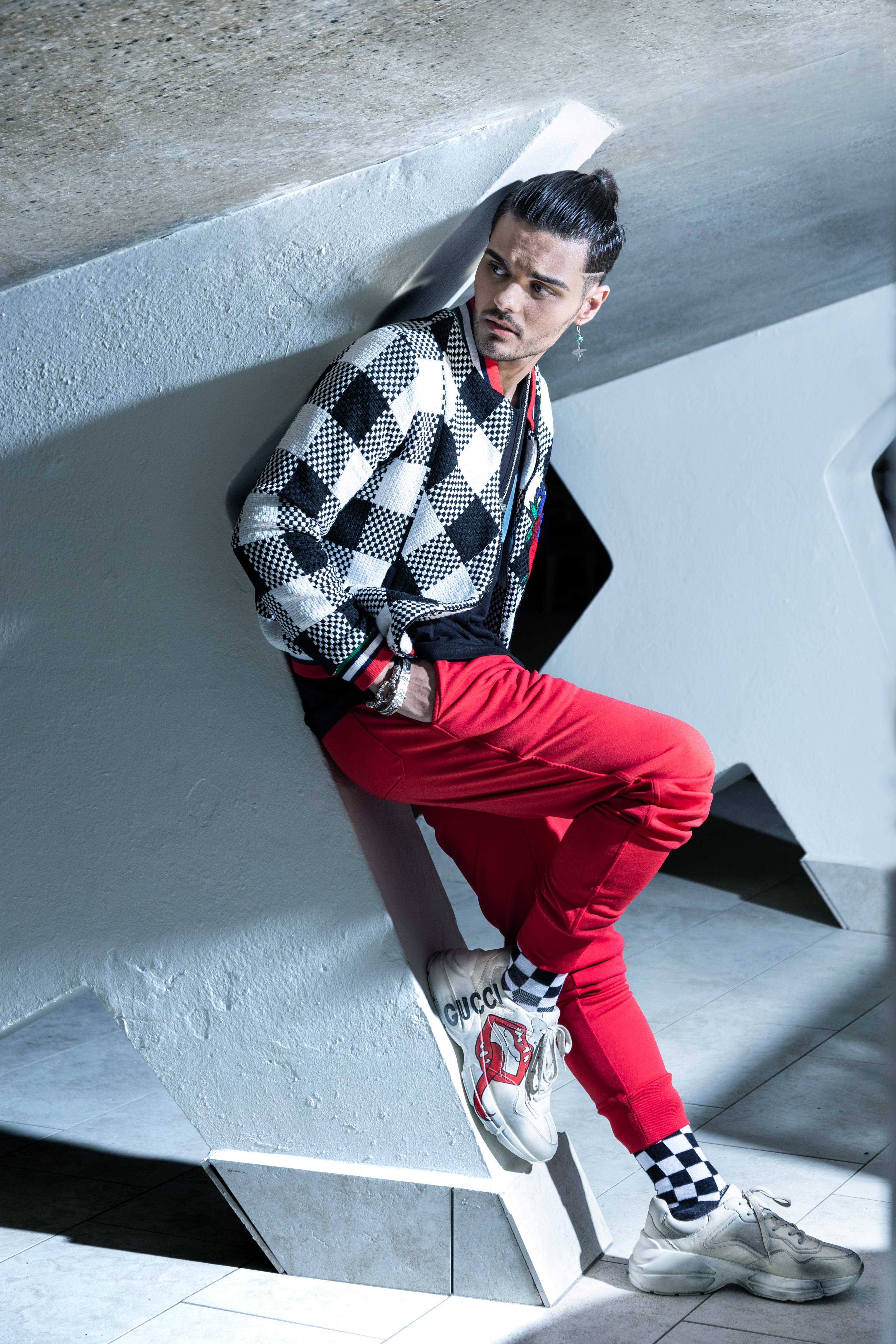 “Bomber jacket”, de Miriam Budet; camisa negra, de Apolo; pantalón rojo tipo “sweat pants”, de Euromoda; tennis Gucci, The Mall of San Juan; y accesorios Konstantino, Stephen Webster & Kings Baby, de Kiyume en Plaza las Américas.