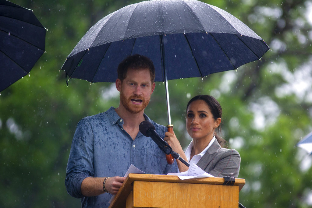 La imagen de Meghan Markle, cuyo embarazo se acaba de anunciar , cubriendo a su esposo con un paraguas se volvió viral en las redes sociales. (Foto: AP)