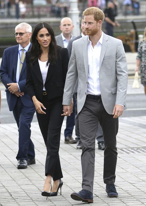 A su llegada al Museo de Emigración Irlandesa, en Dublín, Markle llamó la atención con un conjunto de pantalón de pierna recta y chaqueta clásica en color negro y blusa blanca, de Givenchy. Lo acompañó con “pumps” y cartera sobre también negros. (AP)