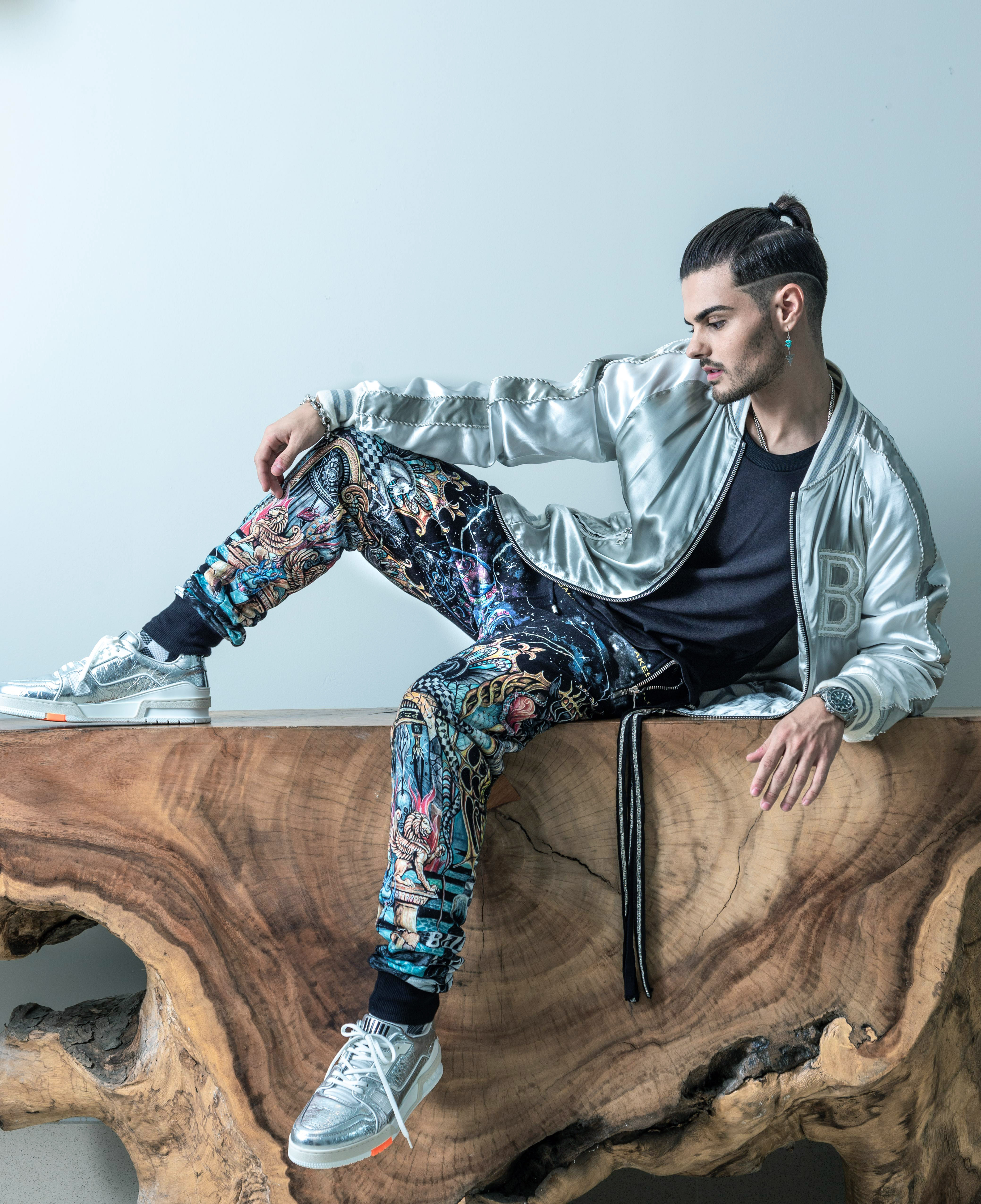 “Bomber jacket” y pantalón Balmain; camisa negra con tiras del diseñador Moti Chasson; tennis Louis Vuitton, The Mall of San Juan; y accesorios de Kiyume, en Plaza Las Américas.