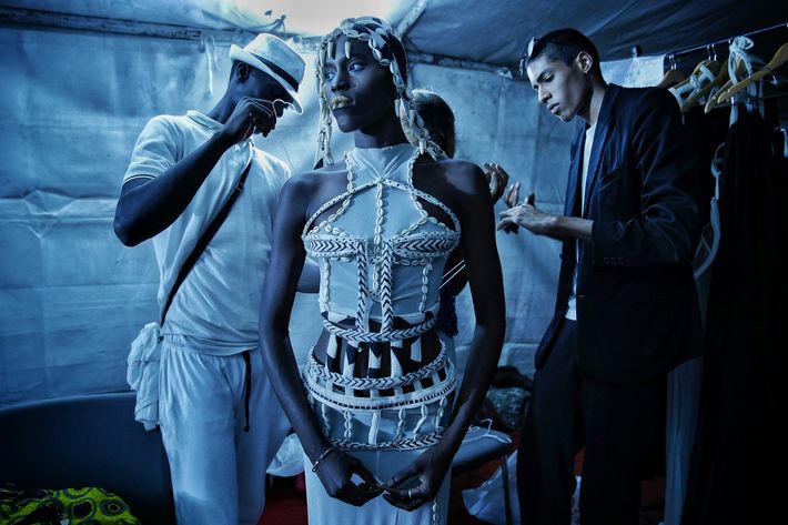 El diseñador Oumar Dicko, a la derecha, de Mali y Bélgica, viste a una modelo con una de sus creaciones durante la Semana de la Moda de Dakar, en la capital senegalesa. (Prensa Asociada)